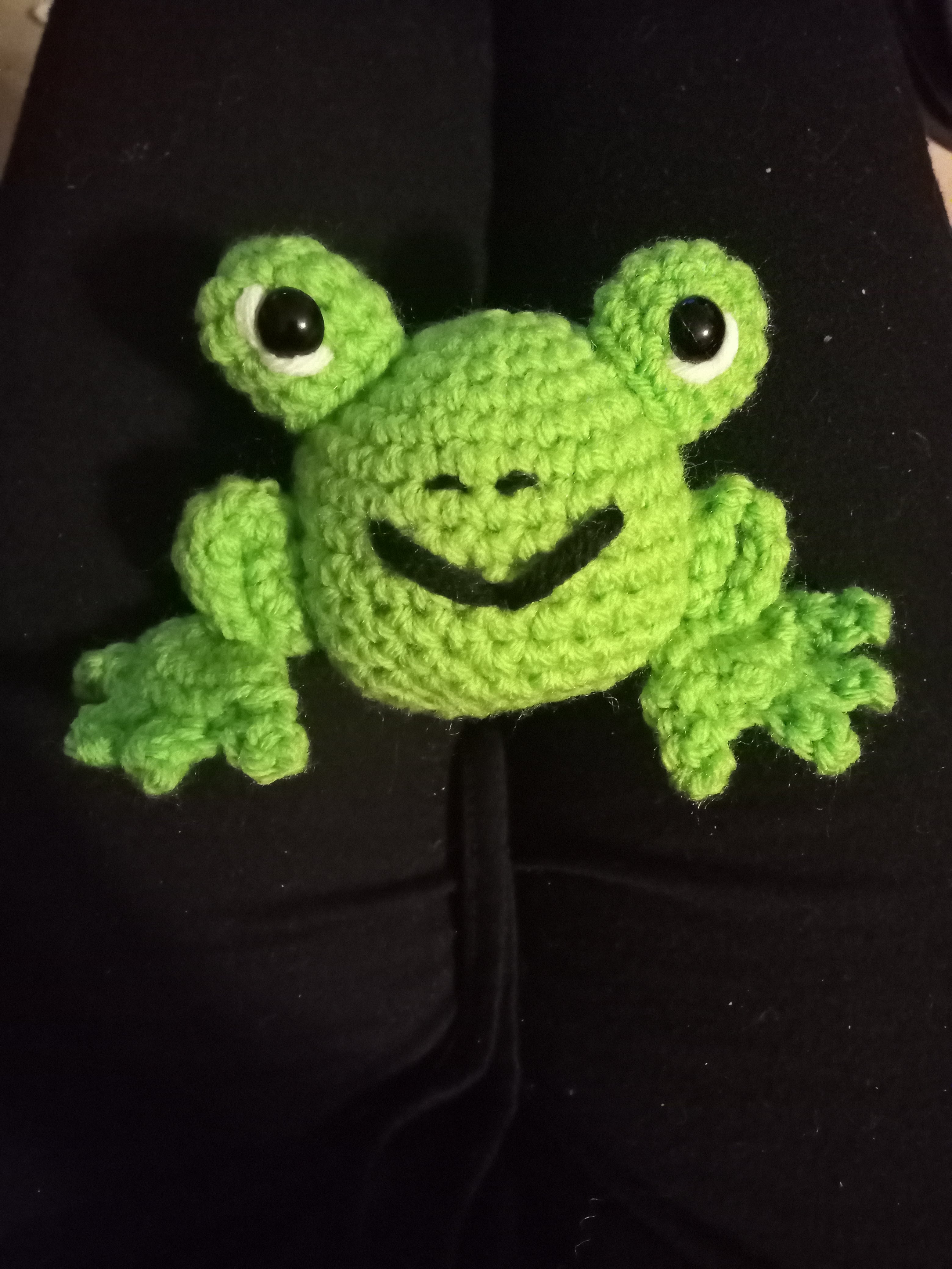 a cute crocheted smiling green frog