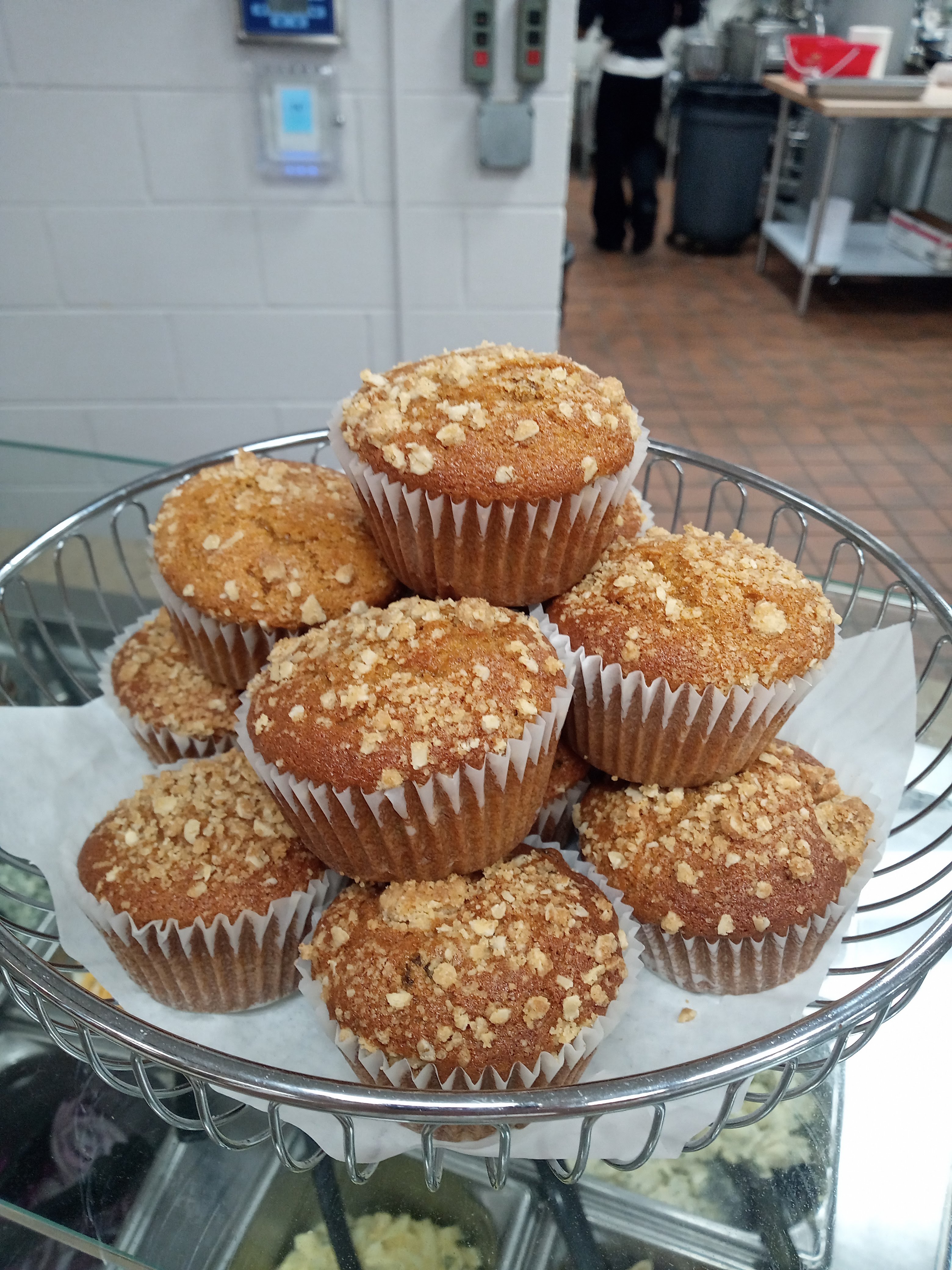 a wire basket filled with a neat stack of streusel topped muffins