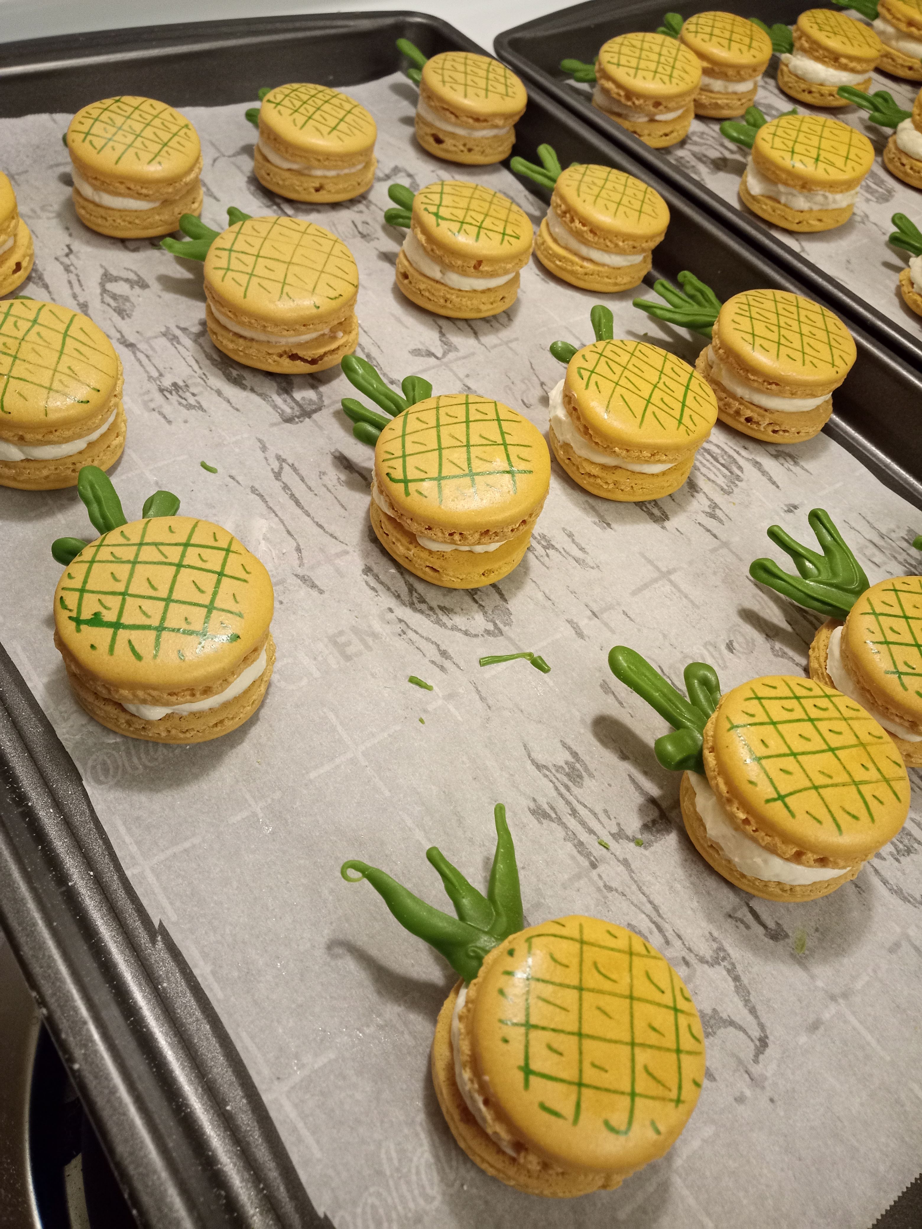 yellow macarons decorated with green white chocolate to look like pineapples